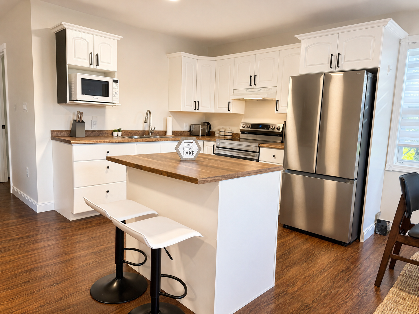 Modern kitchen with island seating at Grand Lake Pine Cottage vacation rental in New Brunswick